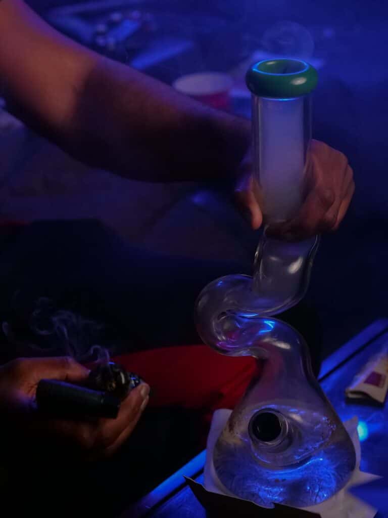 photo of person holding clear glass water bong